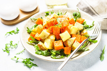 Warm salad with pumpkin, potato and arugula.