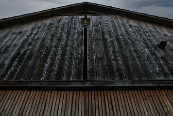 Fassade eines rustikalen und mystisch sowie düster wirkenden Holzhauses mit Bewegungsmelder und...