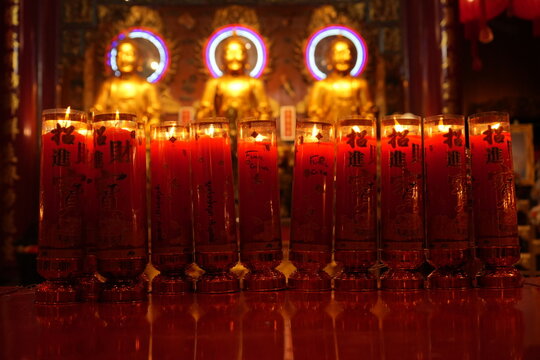 Bangkok : temple bouddhiste dans le quartier chinois avec de nombreux lampions rouges et autels o&ugrave; brulent des bougies  devant des statues de bouddhas dor&eacute;s 