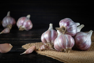 Peeled garlic cloves and heads on a burlap and a chopping table before cooking. Pleasant products. Copy Space