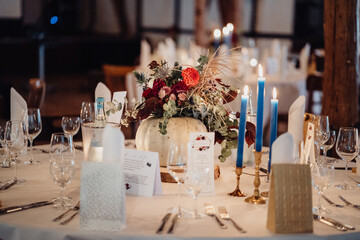 Gedeckter Tisch auf Hochzeitsfeier mit Blumen und Kerzen