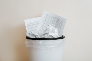 Close-up of crumpled paper, documents, financial reports in trash can