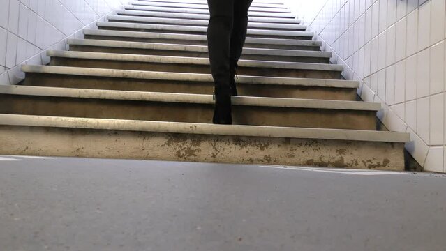 pieds avec talons d'une jeune femme montant des escaliers de m&eacute;tro