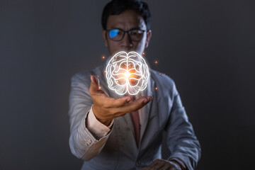 Close up of businessman hand holding brain in palm, Virtual reality man with symbol neurons in the brain. Concept of idea and innovation, on wooden table.