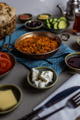 Turkish breakfast served with side dishes and menemen scrambled eggs in tomato sauce