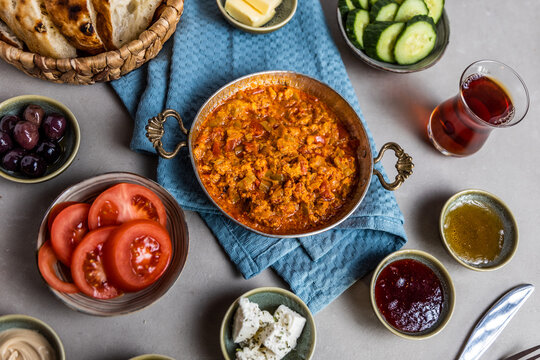 Turkish breakfast served with side dishes and menemen scrambled eggs in tomato sauce