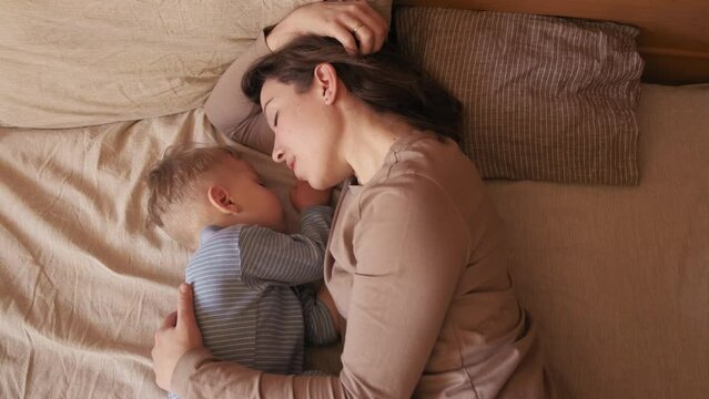 mom next to a sleeping baby. sleeping baby. mom whispers in the ear of a sleeping child. mom kisses sleeping baby