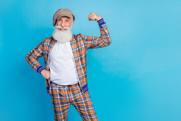 Photo of confident charming retired man dressed plaid suit rising fists empty space isolated blue color background