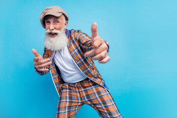 Photo of cheerful cool retired man dressed plaid suit pointing fingers you dancing empty space isolated blue color background