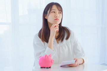 電卓を片手に困った表情をする女性