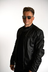 Obraz premium Portrait of handsome male. Sexy stylish man dressed in a leather jacket and sunglasses. Fashion hipster male isolated on white background in studio
