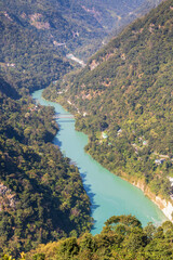 Teesta River with its unique green color water flows through a lush green mountain valley.