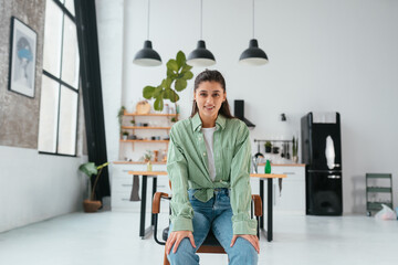 Woman sitting on a chair in a modern kitchen