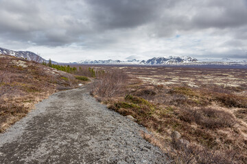 Thingvellir, strada che porta verso una estesa pianura circondata da montagne innevate