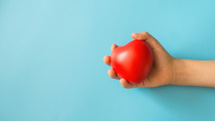 children's hand squeezes a toy heart on a blue background, blood donation, help children, children's hospital, organ transplant, psychological help for children