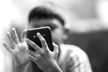 hands of a boy texting on a smartphone and face blurred