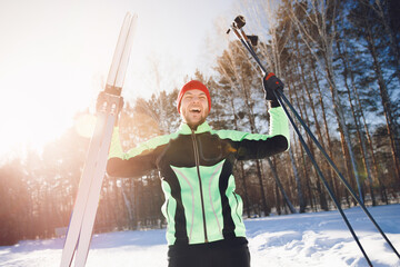 Portrait sportsman happy man with cross country skiing background winter forest, sunny day