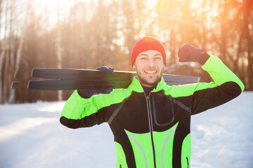 Concept habits for healthy lifestyle. Happy man Cross country skiing in winter on snowy track, sunset background