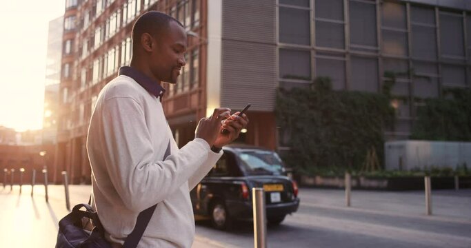 City, man and phone or working on social media or 5g networking communication. Black man, freelance worker and standing in city street for web search app or email on mobile smartphone in urban town