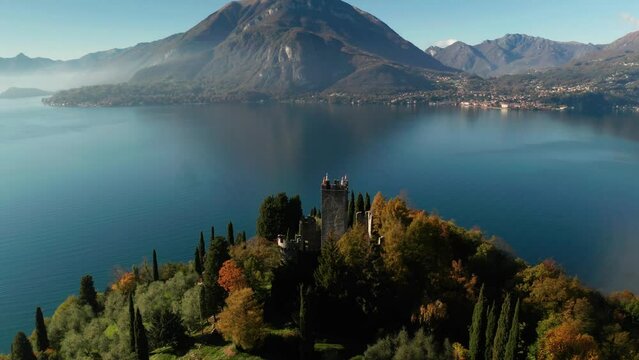 Scenic aerial view of Vezio Castle, above the Varenna town, at the center of Lake Como in northern Italy. Vezio castle is an ancient military outpost of early medieval origin