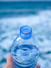 Thirsty water bottle. first person view of a bottle of water with nature background. Top view of a...