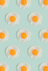 Flat lay pattern with poached eggs on a light mint green background. Minimal concept food concept. Trendy mockup or a wallpaper
