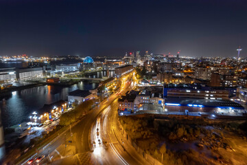 Fototapeta premium Aerial River Mersey and Liverpool skyline at night with light streaks from traffic
