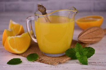 Orange cream (English citrus cream) in a glass gravy boat on a light wooden background.
