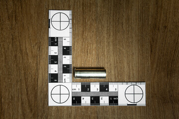 Crime Scene Investigation - bullet casing as a piece of evidence placed with forensic ruler for...