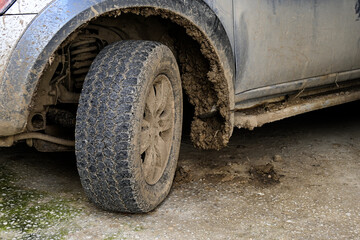 Fototapeta na wymiar closeup of a muddy tire and dirty car