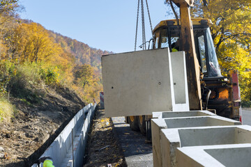 Installing u-shaped concrete drains in reconstruction road involved drainage work to be carried out...