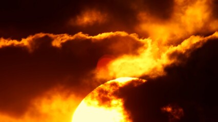 African sunset time lapse with big sun disk and backlit clouds. Cinematic and epic hot summer sunset with big red and orange sun circle.