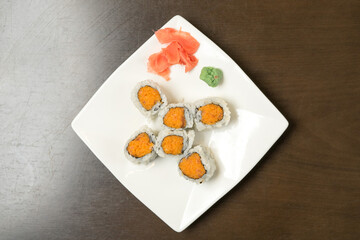 Spicy salmon sushi roll on plate