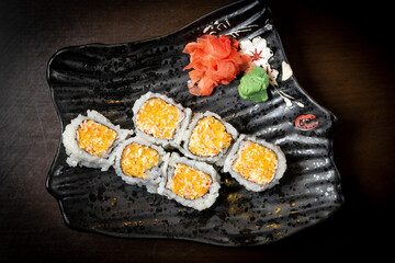 Spicy salmon sushi roll on a plate