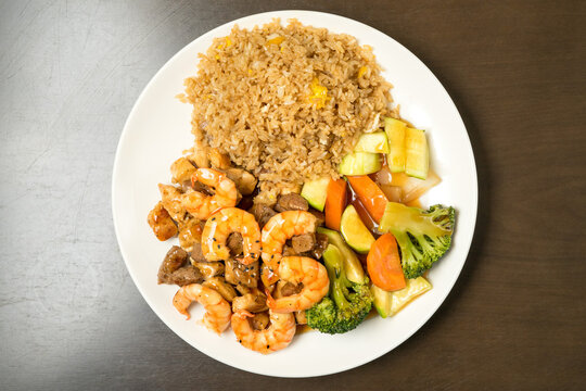 Steak and shrimp hibachi on a plate with rice and vegetables
