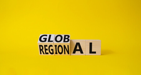 Global and Regional symbol. Turned wooden cubes with words Regional and Global. Beautiful yellow background. Business and Global and Regional concept. Copy space