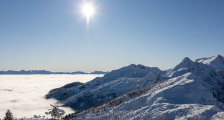 Winter mountains covered with snow landscape over clouds