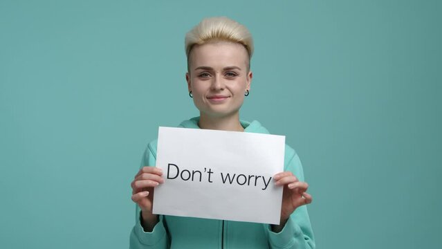 Caucasian, blonde-haired woman with a positive facial emotions. Young girl holding a white card with optimistic expression. High quality 4k footage