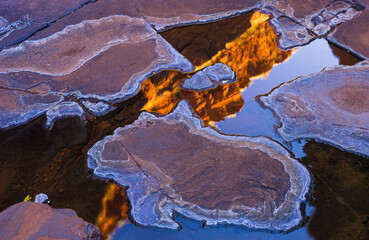 Walls of a narrow slot canyon reflect in a little pool of water, Karijini National Park, Western...