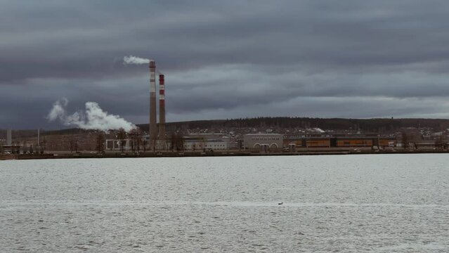 View of the tall chimneys of an industrial enterprise with a chimney polluting the atmosphere. The plant for the production of strategic intercontinental missiles "Topol-M". Russia, Votkinsk 2022