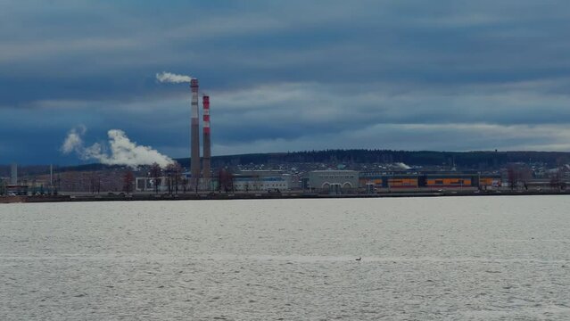 View of the tall chimneys of an industrial enterprise with a chimney polluting the atmosphere. The plant for the production of strategic intercontinental missiles "Topol-M". Russia, Votkinsk 2022