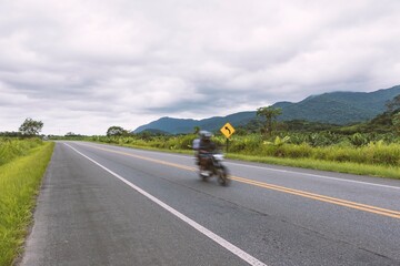 Motorcycle passing through the highway in the rainforest. traffic on the Padre Manoel da N&oacute;brega Highway, SP 55, Brazil.