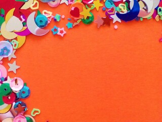 Birthday postcard made of heart shaped confetti, moons and stars on orange background