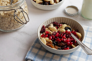 Muesli in a bowl, with dried fruits and nuts and pomegranate seeds