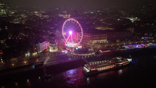 Dusseldorf christmas market and ferris wheel in germany at night. Skyline and rhine river aerial drone view. Night time in winter. Aerial