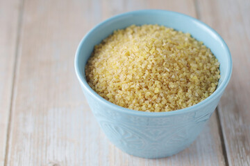 Dry uncooked bulgur in a ceramic bowl	