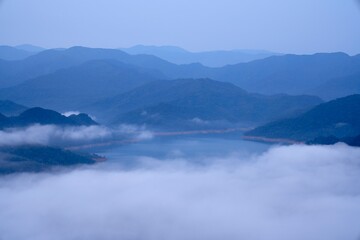 Fototapeta na wymiar foggy clouds and mountains in blue tones before sunrise
