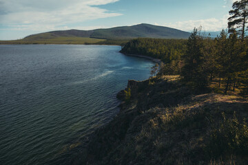 mountainous area with a body of water, blue clear water, cirrus clouds