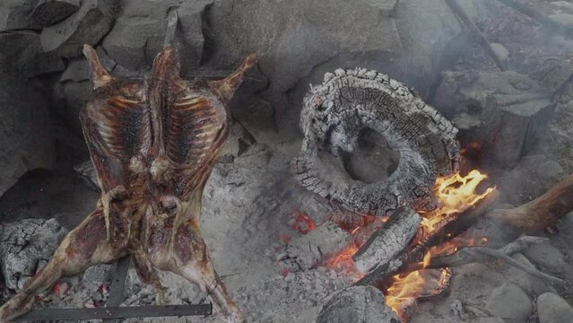 rustic lamb barbecue bbq over open fire in Patagonia, Argentina, South America. Asado is a Gaucho traditon with cooking on open flame