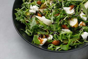 Diet salad with green arugula, feta cheese and pears, almond nuts. Delicacy fresh Green fruit salad...